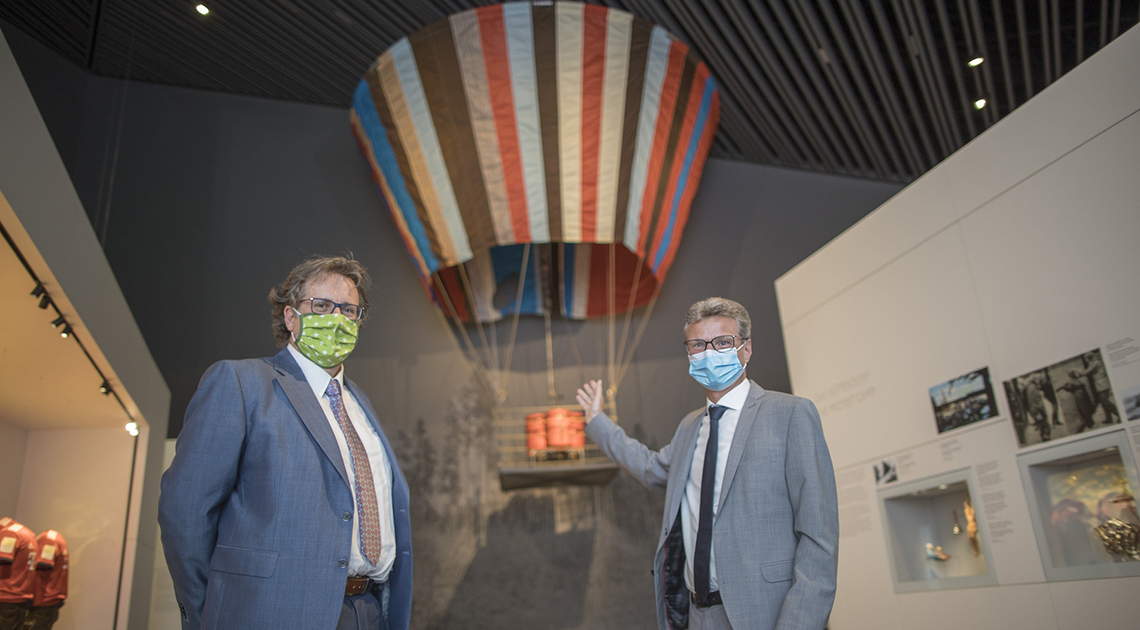 Bei der Wiedereröffnung sind der bayerische Kunstminister Bernd Sibler (rechts) und der Direktor des Hauses der Bayerischen Geschichte, Dr. Richard Loibl, vor der Inszenierung des Fluchtballons von Naila zu sehen