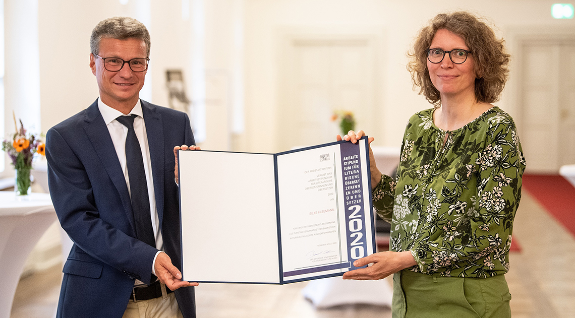 Kunstminister Bernd Sibler überreicht die Urkunde zum Arbeitsstipendium des Freistaats Bayern 2020 für literarische Übersetzerinnen und Übersetzer an Silke Kleemann