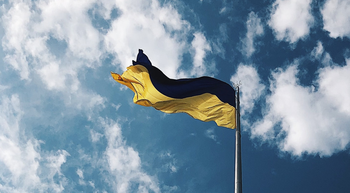 Die ukrainische Flagge vor blauem Himmel mit weißen Wolken (Foto: Daria Volkova/Unsplash)